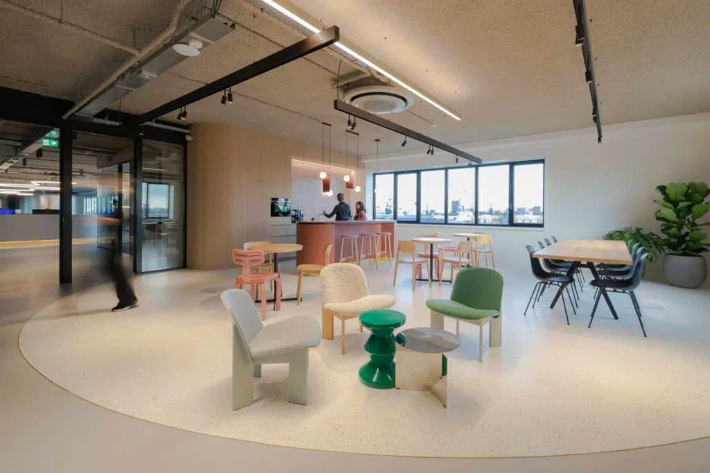 Sfeervolle kantoorinrichting in Deurne met organische vormen, diverse design stoelen en een duurzame, biobased pantry op de achtergrond.